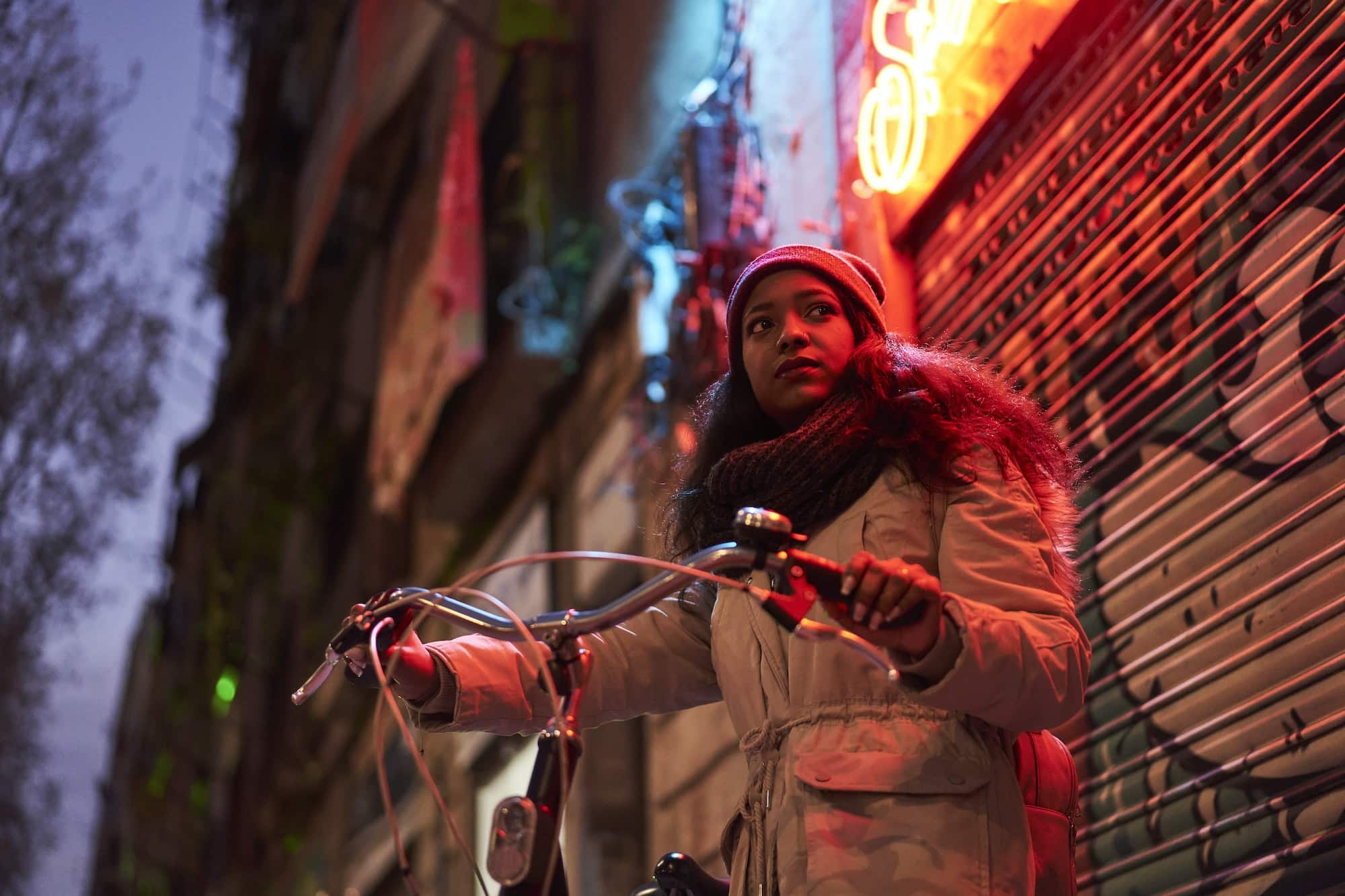Black woman in winter clothes looks seriously into the camera