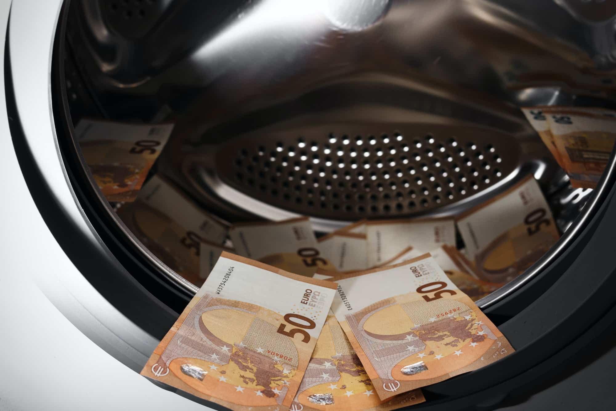 50 euro banknotes inside washing machine. Money laundering symbol. Tax evasion. Illegal financial
