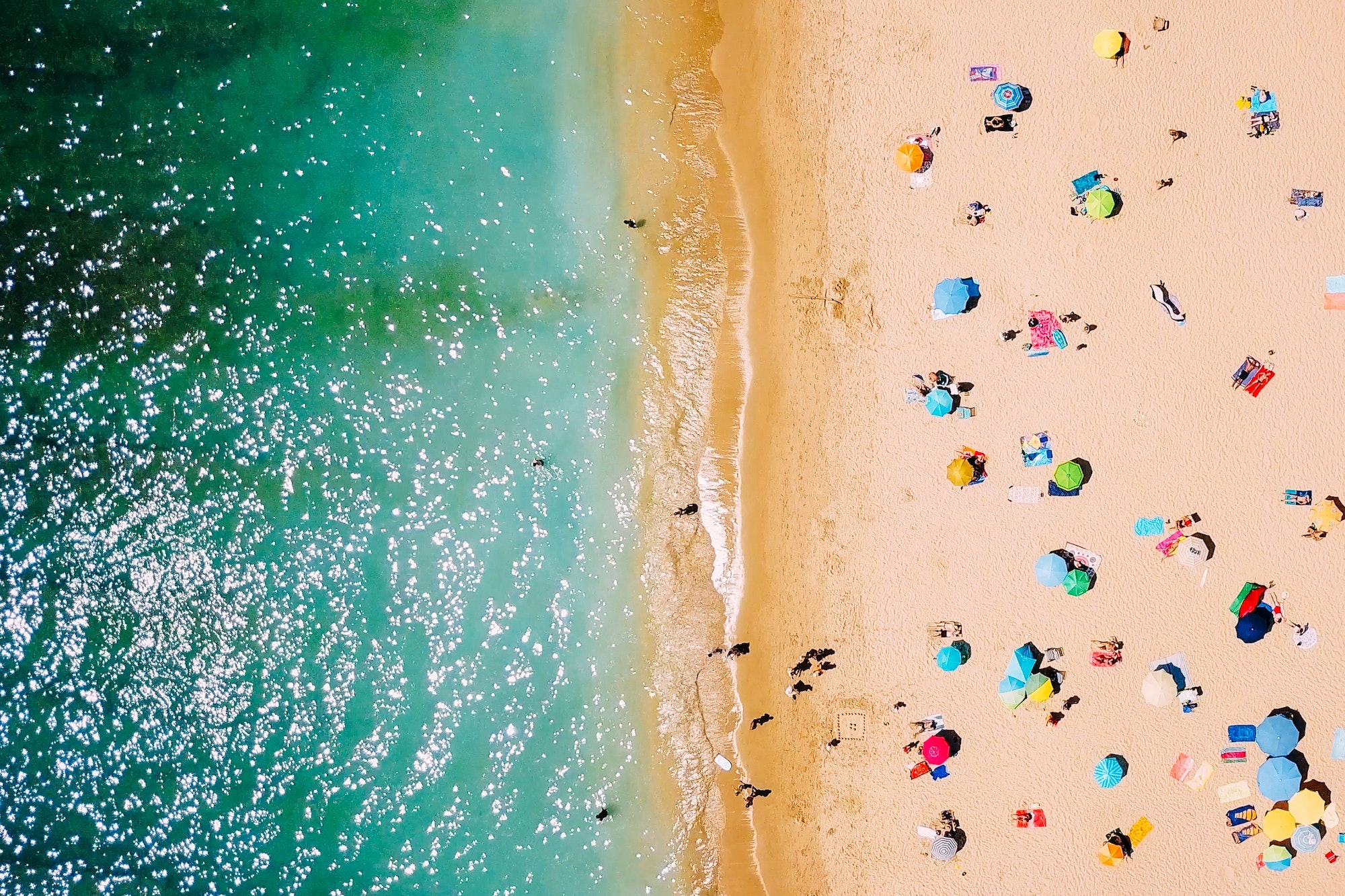 Aerial View From Flying Drone Of People Crowd Relaxing On Beach In Portugal