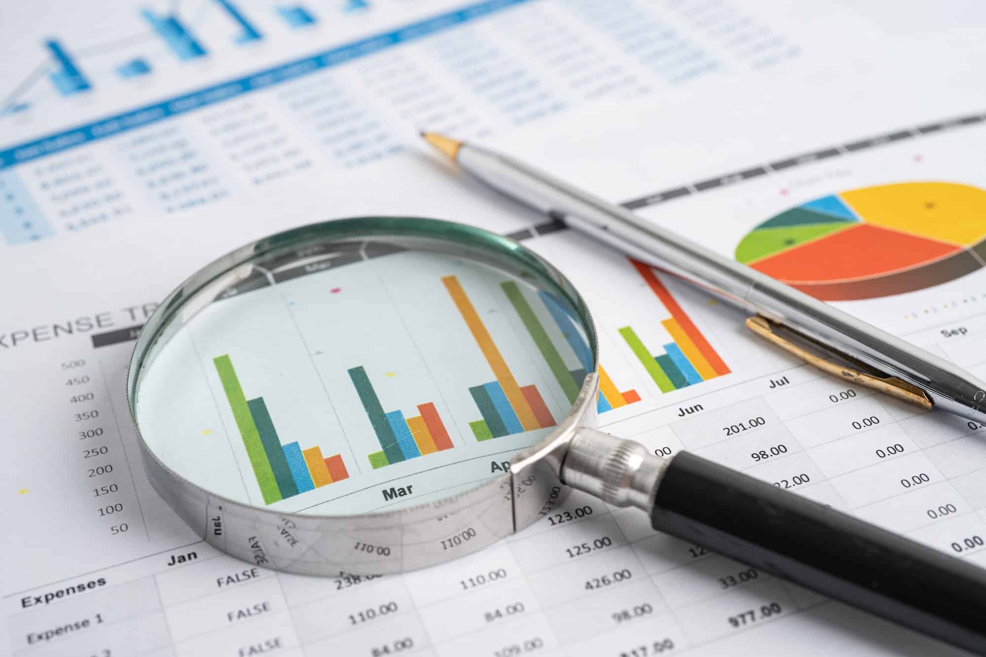 Magnifying glass on charts graphs paper. Financial development, Banking Account, Statistics