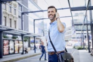 Businessman talking on phone and using public transport