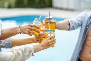 Clinking bottles with drinks outdoors