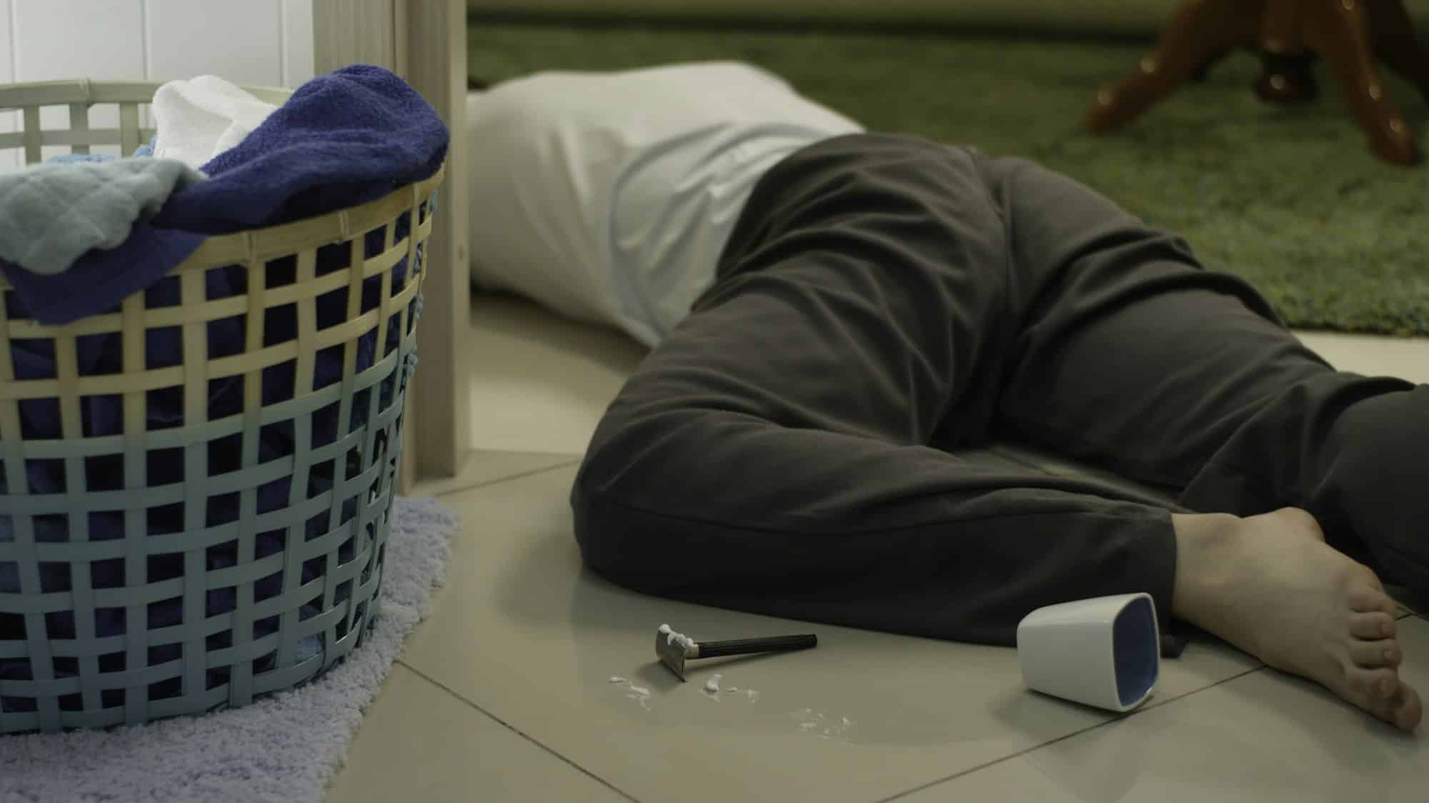 Dead man lies on the carpet and lying next to a razor for shaving. Young handyman fell from a ladder