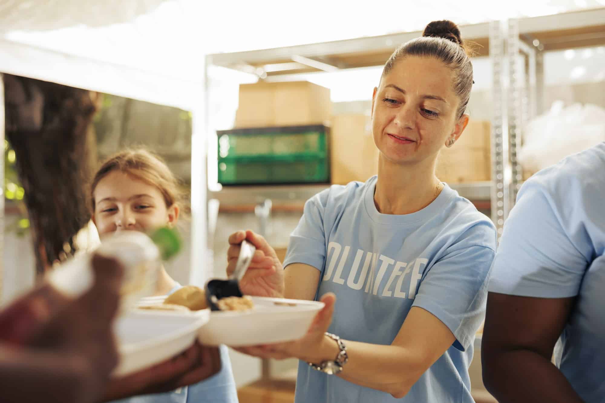 Woman handing out food to the homeless