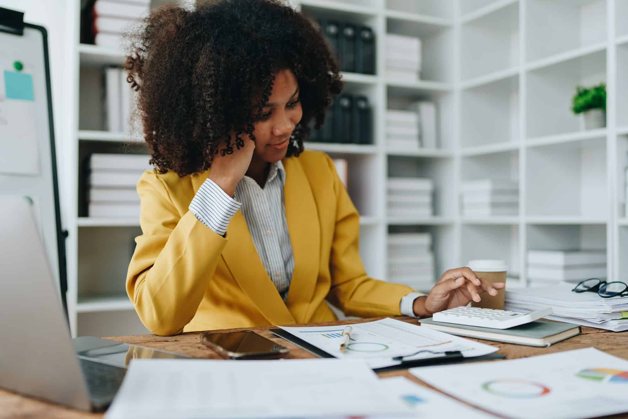 Young asian female work with financial papers at home count on calculator before paying taxes